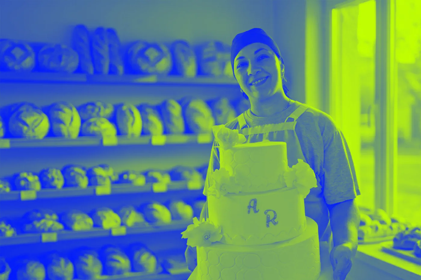 Una emprendedora sanjuanina con una torta que hizo, en su panadería