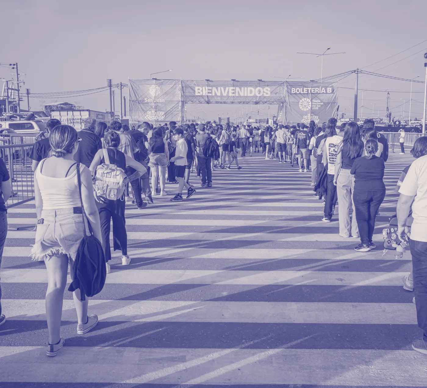 Público entrando a la Feria bajo el cartel de bienvenida