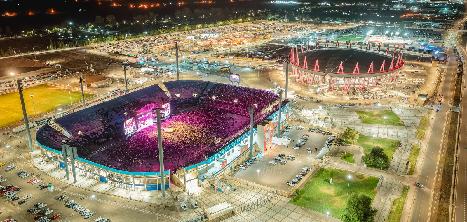 Vista aérea nocturna del predio de la Fiesta Nacional del Sol, con el Estadio del Bicentenario y el estacionamiento